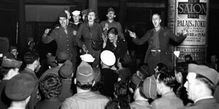 Schwarzweißfoto von singende Soldaten.