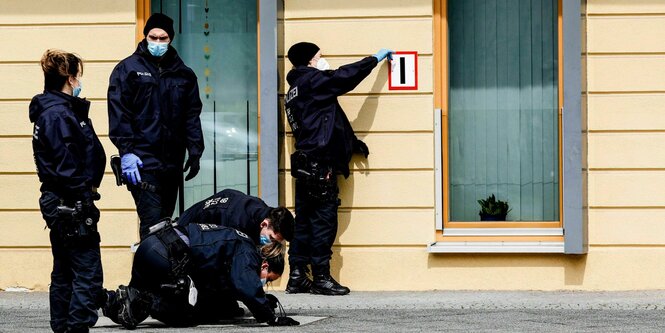 eine Gruppe von PolizistInnen untersucht das Gebäude