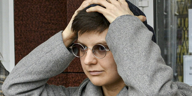 Julia Tzwetkowa steht vor dem Gerichtsgebäude, die Hände über dem Kopf zusammengeschlagen