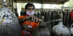 Ein Arbeiter befüllt im indischen Prayagraj Sauerstoffflaschen