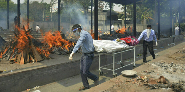 Angehörige tragen einen toten Körper zum Krematorium in Neu Delhi