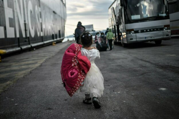 Ein kleines Mädchen mit Kleid geht zu einem Bus.