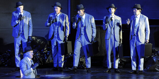Sechs graue Herren rauchen auf der Bühne des Thalia Theaters Zigarren