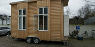 Ein mobiles Holzhaus auf einem Parkplatz.