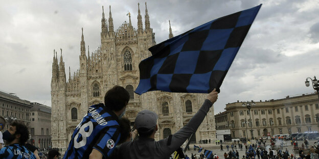 Fanhenschwenkende Fans auf dem Platz vor der Kathedrale in Mailand