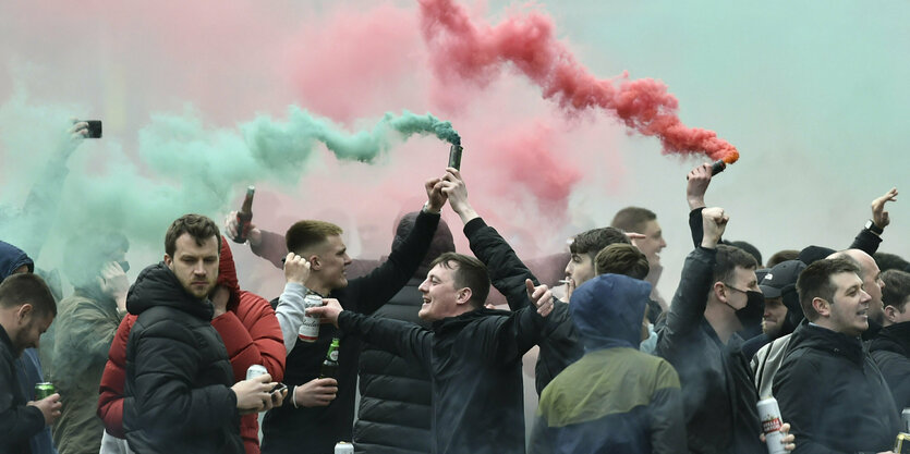 Fans mit grünen und roten Rauchtöpfen