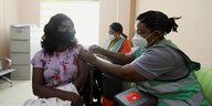 Eine Frau bekommt von einer medizinischen Fachkraft eine Imfung gegen Covid-19 in einem Krankenhaus