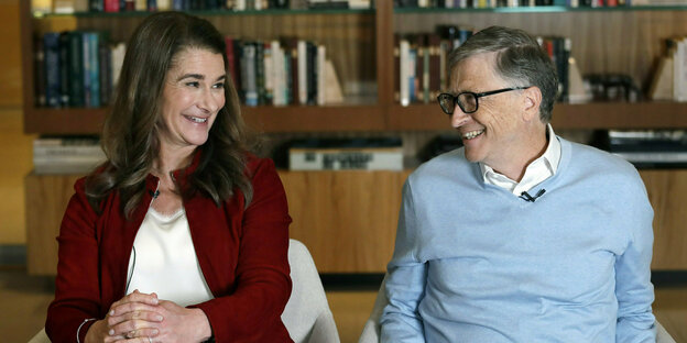 Melinda und Bill Gates sitzen auf Sesseln und lächeln sich an