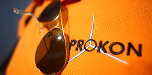 Prokon-T-Shirt auf dem eine Sonnenbrille liegt