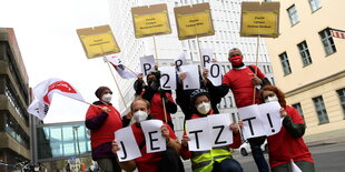 Menschen mit Protestschildern stehen auf der Straße