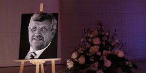 Ein Foto von Walter Lübcke ist neben Blumen während einer Gedenkfeier aufgestellt