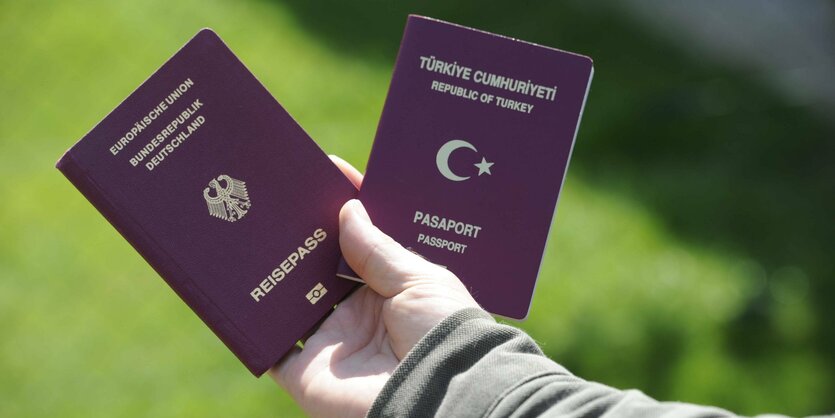 Jemand hält einen türkischen und einen deutschen Reisapass in der Hand