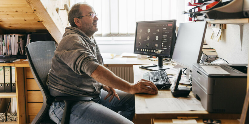 Ein Mann sitzt vor seinem PC.