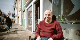 Jörn Neitzel sitzt vor einem Ladenlokal in Bremen.