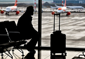 Ein Mann mit einem Koffer wartet auf seinen Flug