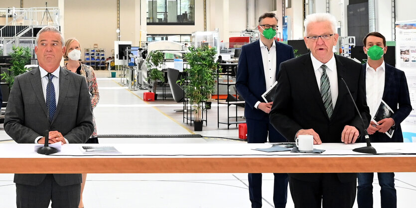 Thomas Strobl und Winfried Kretschmann stehen an einem Tisch