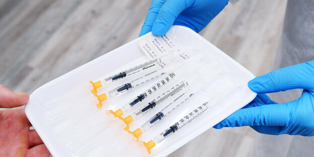 6 Spritzen Biontech Impfstoff werden gereicht in einer Schale