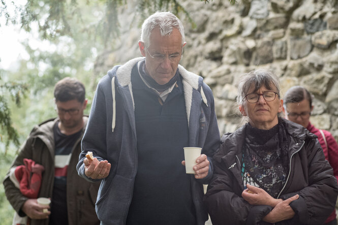 Louven hat einen Plastikbecher und Brot in der Hand beim Abendmal