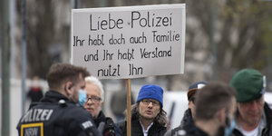 Teilnehmer der Demonstration der Initiative "Querdenken" halten ein Banner mit der Aufschrift "Liebe Polizei, Ihr habt doch auch Familie und Ihr habt Verstand - nutzt ihn" hoch.