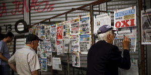 Menschen lesen Zeitung in Athen