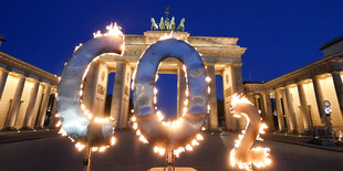 Ein brennendes CO²-Symbol vor dem Brandenburger Tor