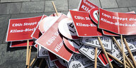 Schilder liegen auf dem Asphalt: CDU: Stoppt die Klima-Blockade