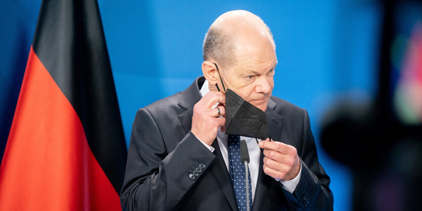 Olaf Scholz nimmt seine Maske ab