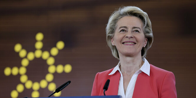 Ursula von der Leyen steht vor Sonnenlogo