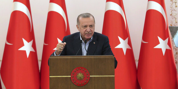 Der türkische Präsident Erdogan am Rednerpult. Hinter ihm vier türkische Flaggen