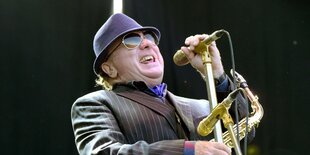 Van Morrison mit Jacket und Hut steht am Mikrofon