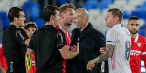 Schiedsrichter und Trainer Zidane sowie mehrere Spieler beim Diskutieren