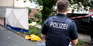 In der Wohnanlage Breitenbachhof in Gröpelingen steht ein Polizist mit dem Rücken zum Betrachter. Teile der Hoffläche sind mit Flatterband abgesperrt. Hier wurde Mohammed Idrissi erschossen.