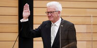 Ministerpräsident Winfried Kretschmann hält die Hand hoch zur Vereidigung