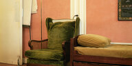 Ein grüner Sessel steht neben einer Recamiere