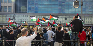 Viele Menschen stehen dicht gedrängt auf dem Hermannplatz. Einige schwenken palästinensische Flaggen.