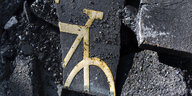 Reste eines aufgemalten Fahrrads auf herausgebrochenem Asphalt