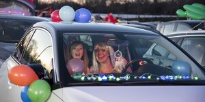 Zwei Frauen in einem Auto, außen am Auto sind Luftballons