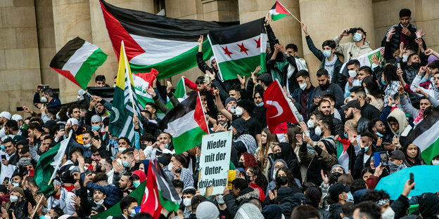 Demonstranten halten in Stuttgart palästinensische Fahnen hoch
