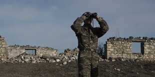 Ein Soldat späht durch ein Fernglas