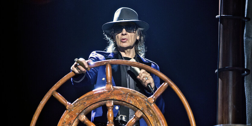 Der Sänger Udo Lindenberg steht bei einem Konzert in Hamburg hinter einem Steuerrad