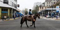 Ein Mann mit Hut reitet nach der Stimmabgabe in Valparaiso auf seinem Pferd über die Straße