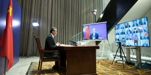 Außenminister Wang Yi vor Bildschirmen.
