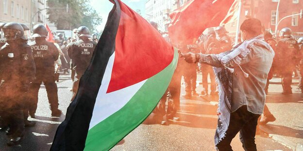 Menschen bei einer Demonstration mit Palästinaflagge.