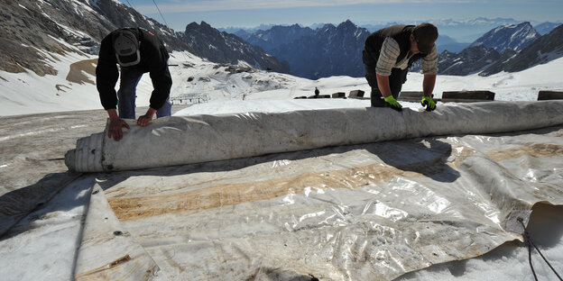 Arbeiter decken den Schneeferner-Gletscher auf der Zugspitze bei Garmisch-Partenkirchen ab. Deutschlands einziger Gletscher erhielt für die Sommerzeit eine großflächige Abdeckung aus Planen und Folien. Dies soll den S