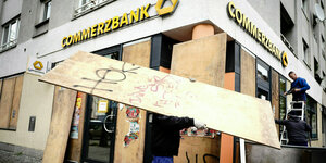 Arbeiter verbarrikadieren die Schaufenster einer Bank Filiale in Berliner Stadtteil Kreuzberg vor dem 1. Mai.