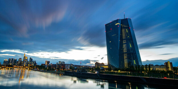 Der Wind treibt kurz nach Sonnenuntergang dunkle Wolken über die abendliche Bankenskyline und die Europäische Zentralbank (EZB) in Frankfurt