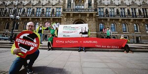 Manfred Brraasch bei Anti-Kohle-Protest vor Hamburger Rathaus, hinter ihm ein rotes Transparent
