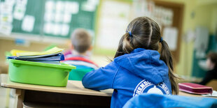 Ein Mädchen sitzt in einem Klassenzimmer