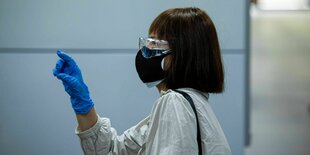 Eine Frau in Taipeh trägt Schutzbrille und doppelten Mundschutz