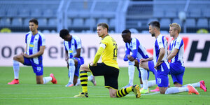 Hertha-Spieler knieen um den Mittelfeldkreis vor dem Anpfiff